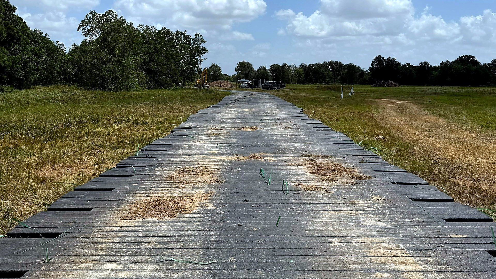 Recycled HDPE mat access road running across open Gulf Coast ground